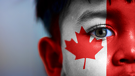 Boy's face, looking at camera, cropped view with digitally placed Canada flag on his face.